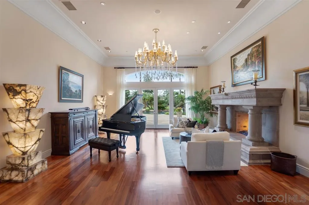 15611 Via De Santa Fe Rancho Santa Fe, CA 92067 - Photo 5 of 25 a living room with fireplace furniture and a chandelier