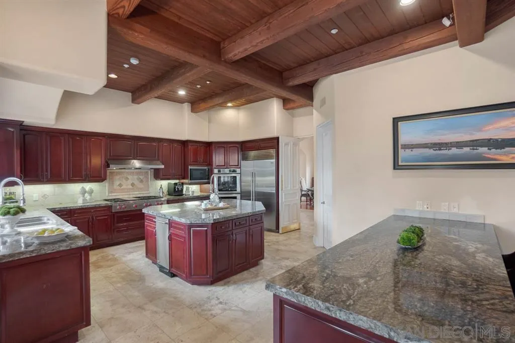 15611 Via De Santa Fe Rancho Santa Fe, CA 92067 - Photo 7 of 25 a kitchen with stainless steel appliances granite countertop a stove a sink and a microwave