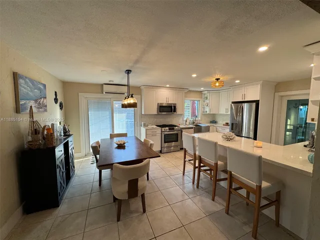 a kitchen with a dining table chairs and refrigerator