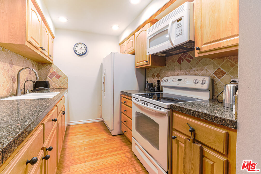 8105 Raintree Circle Culver City, CA 90230 - Photo 2 of 17 a kitchen with stainless steel appliances granite countertop a sink and a refrigerator