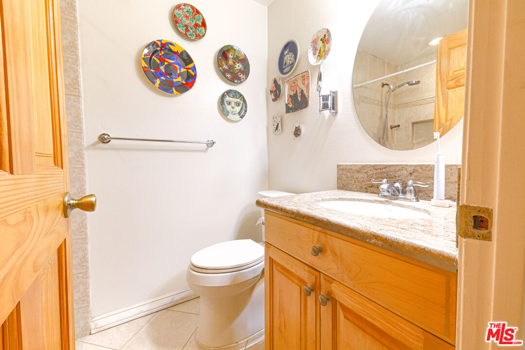 8105 Raintree Circle Culver City, CA 90230 - Photo 9 of 17 a bathroom with a granite countertop sink toilet and a mirror