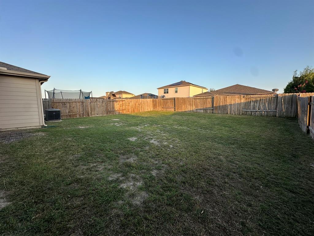 1818 Clegg Street Howe, TX 75459 - Photo 32 of 34 Expansive backyard with a full wood privacy fence and a tan siding exterior on the property