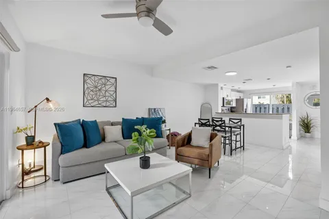a living room with furniture and a dining table with kitchen view