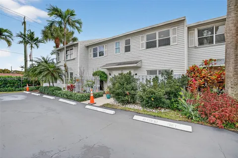 a view of a street with potted plants and palm trees