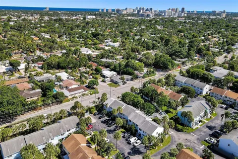 an aerial view of residential houses with outdoor space and trees