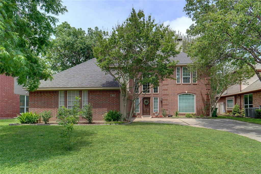 a front view of a house with a yard and trees