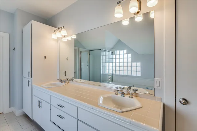 a bathroom with a sink a large mirror and a light fixture