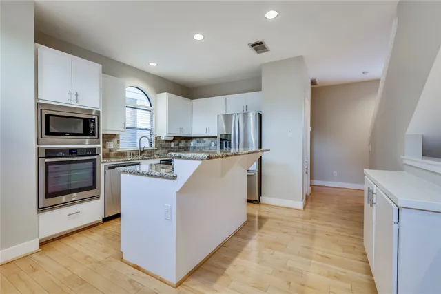 a kitchen with cabinets and stainless steel appliances