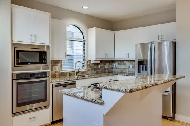 a kitchen with stainless steel appliances granite countertop a stove microwave and refrigerator