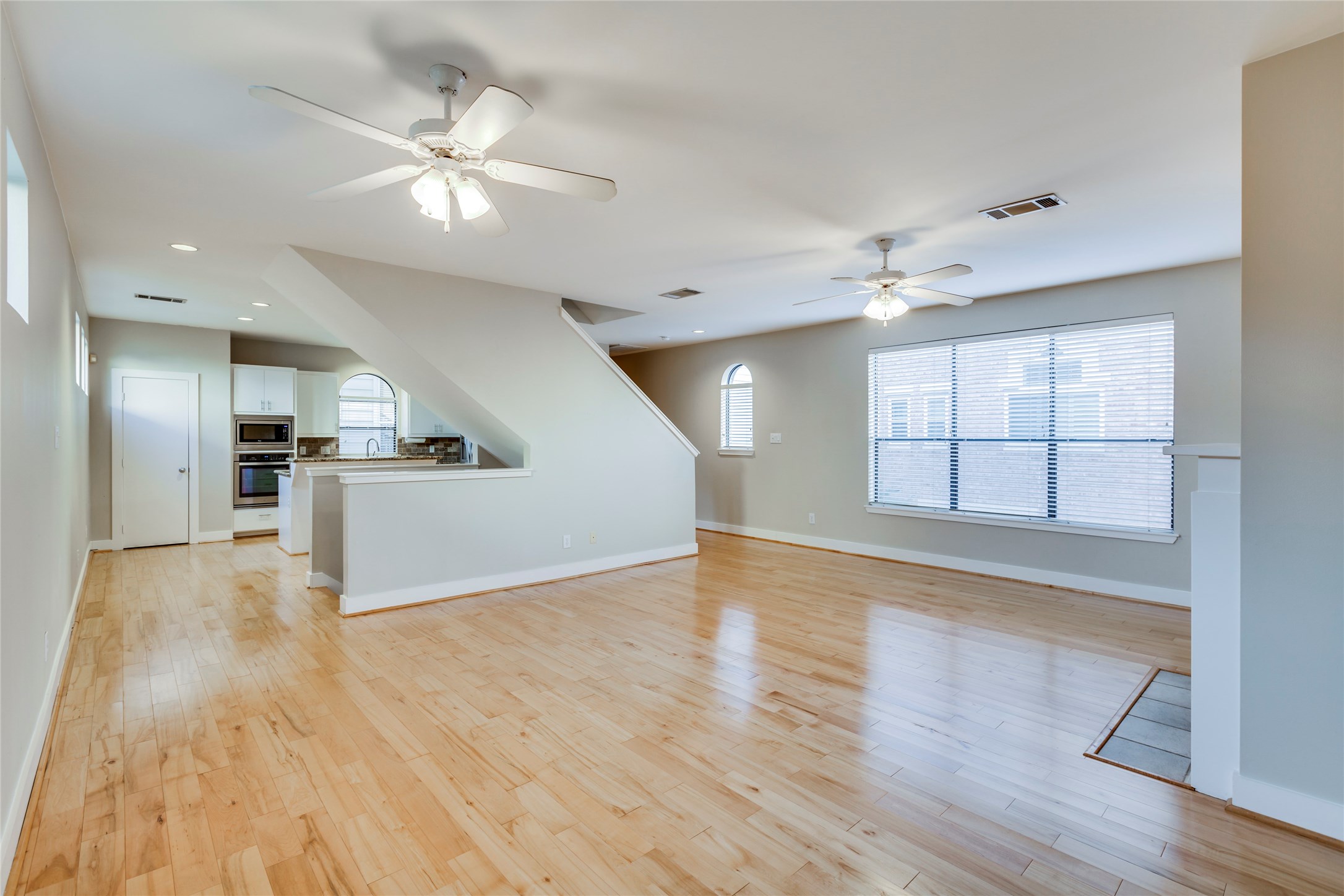 609 Lester Street Houston, TX 77007 - Photo 9 of 31 a view of an empty room with wooden floor and a kitchen