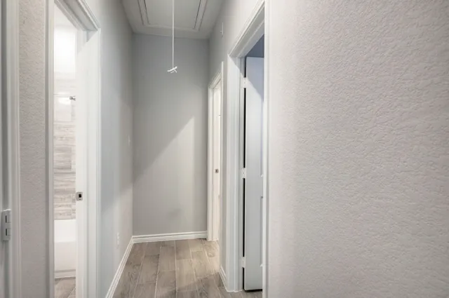 a view of a hallway with wooden floor and closet