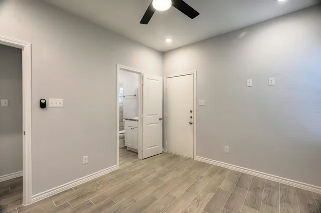 an empty room with chandelier fan and closet area