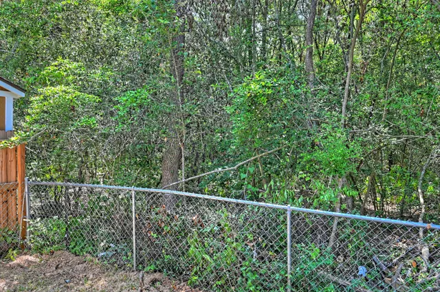 a view of a fence and trees from a window