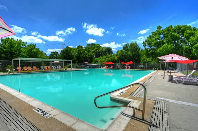 a view of a swimming pool with a table and chairs under an umbrella