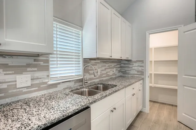 a kitchen with granite countertop a sink and a stove