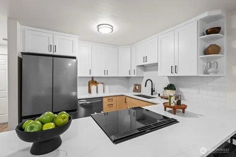 a kitchen with stainless steel appliances granite countertop a sink refrigerator and cabinets