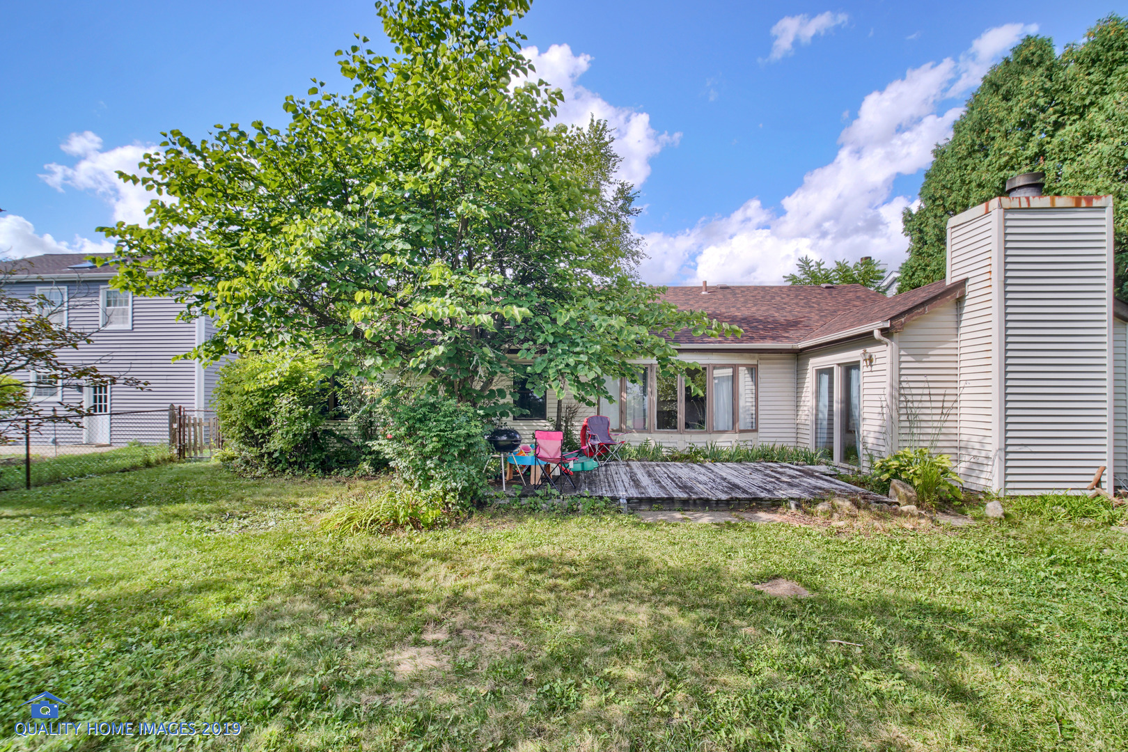 27W241 Churchill Road Winfield, IL 60190 - Photo 19 of 24 a view of a backyard with table and chairs and potted plants