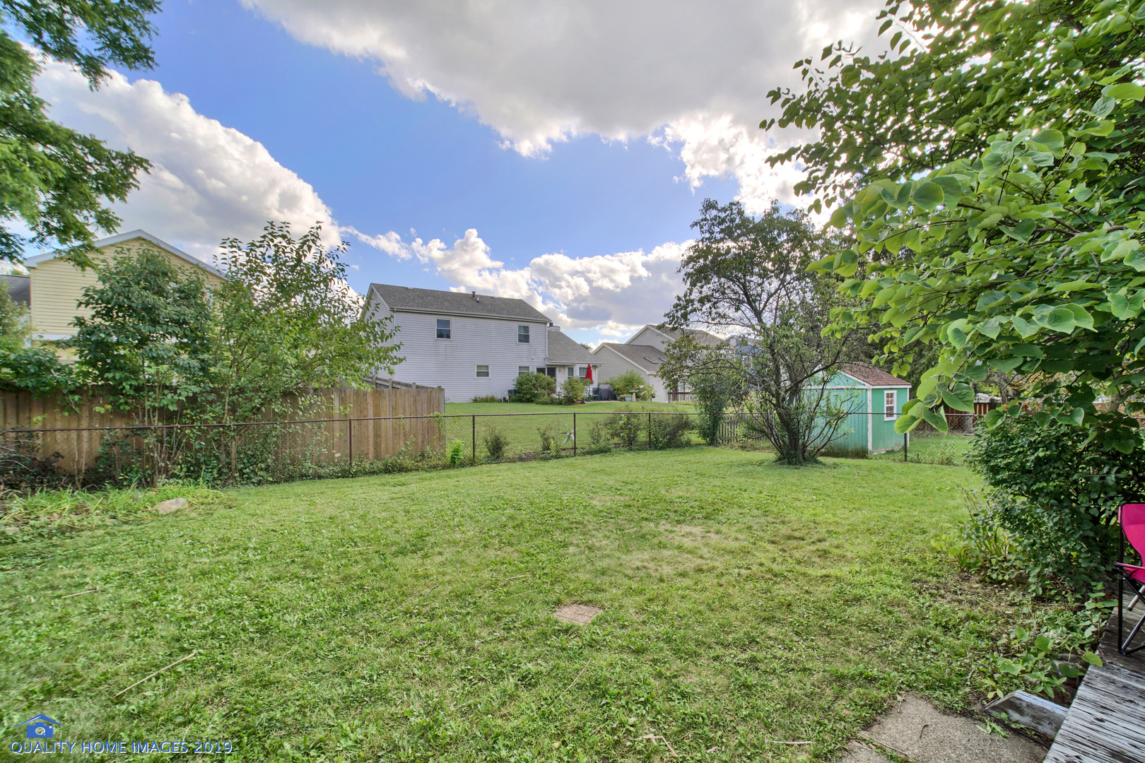 27W241 Churchill Road Winfield, IL 60190 - Photo 22 of 24 a view of a big yard with plants and a large tree