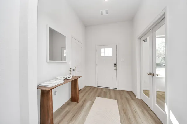 a hallway with a sink and a mirror