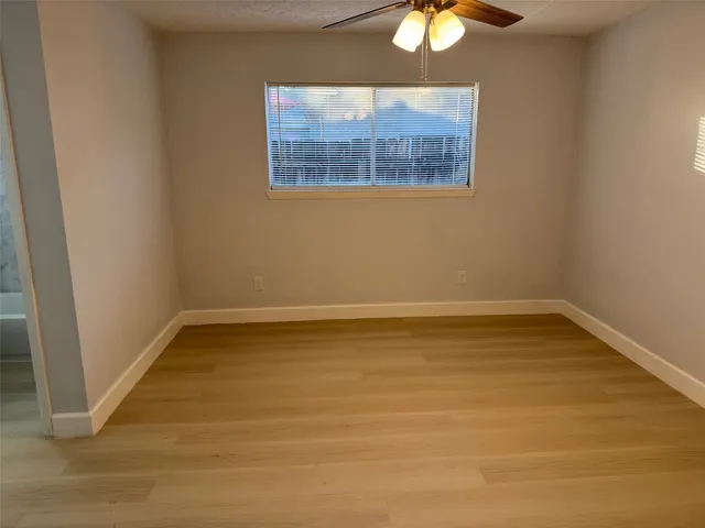 a view of an empty room with a chandelier fan