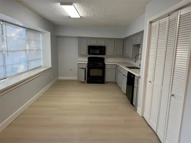 a large kitchen with cabinets and a stove top oven