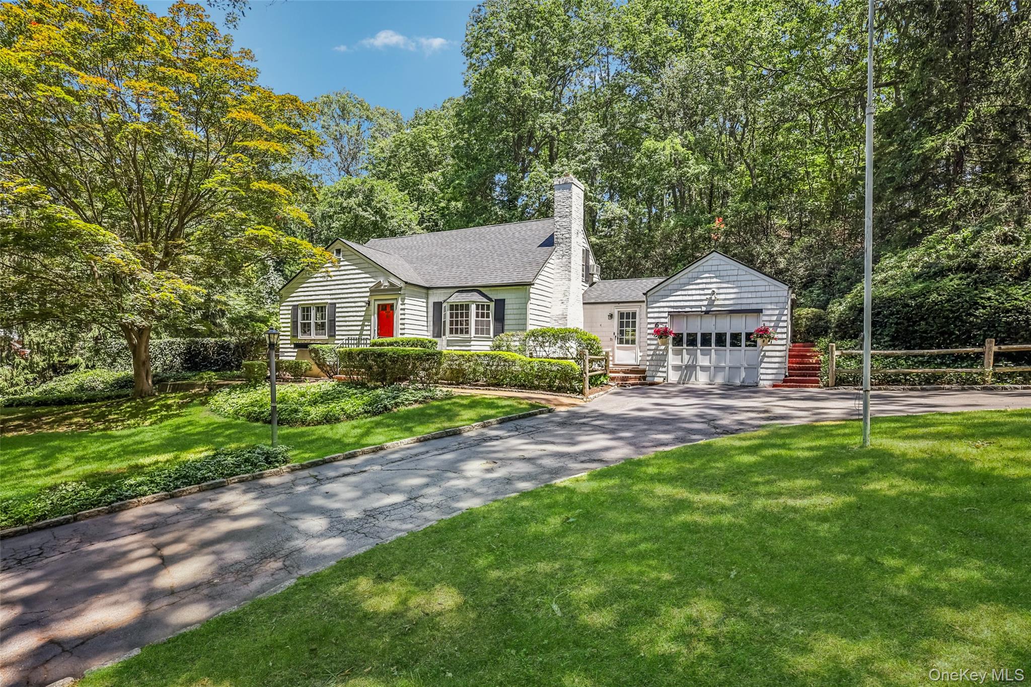 a front view of a house with yard and green space