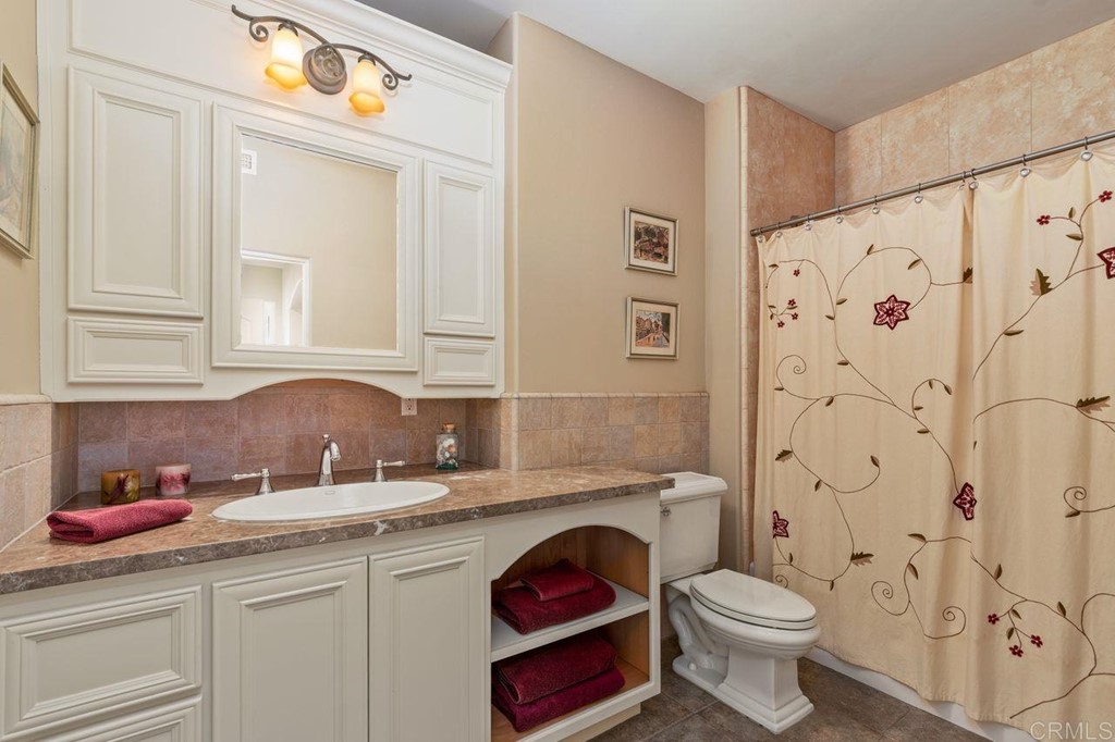 10363 Hidden Meadows Road Escondido, CA 92026 - Photo 43 of 65 a bathroom with a toilet sink vanity granite and shower
