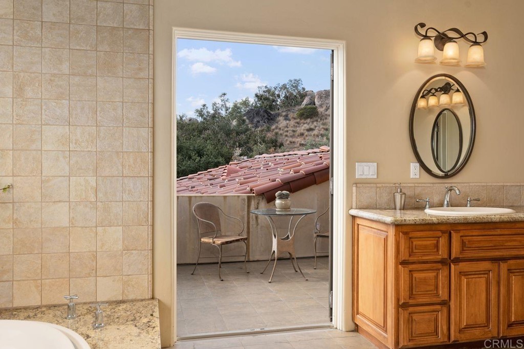10363 Hidden Meadows Road Escondido, CA 92026 - Photo 63 of 65 a bathroom with a granite countertop sink a mirror and a shower