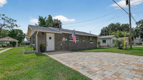 a front view of a house with a yard and trees