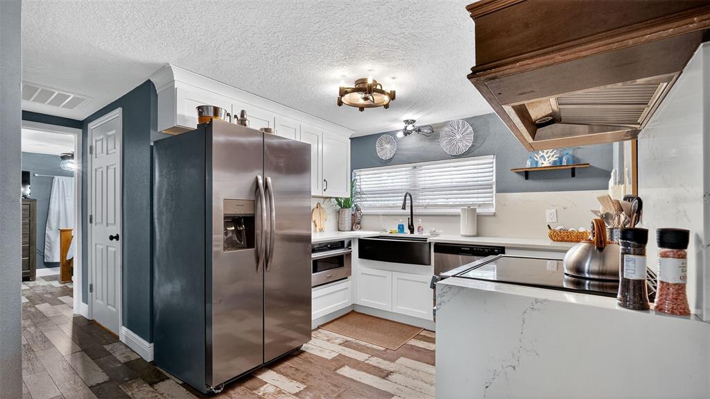5411 Teal Drive Weeki Wachee, FL 34607 - Photo 15 of 44 a kitchen with stainless steel appliances kitchen island granite countertop a refrigerator and a stove