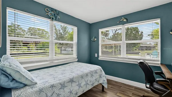 a bedroom with a bed and two windows