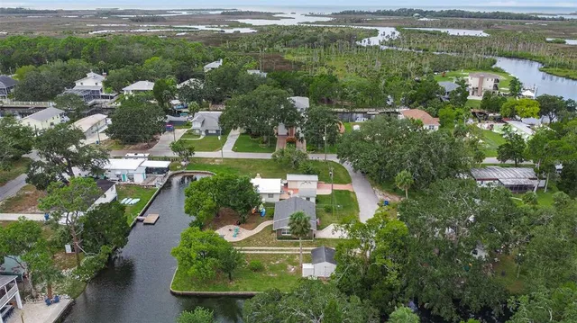 an aerial view of residential houses with outdoor space and lake view