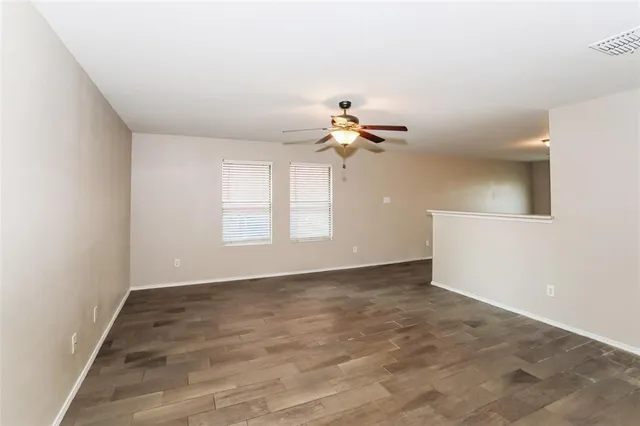 a view of an empty room with a chandelier fan