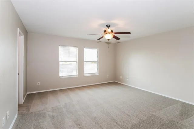 a view of room with a ceiling fan and window