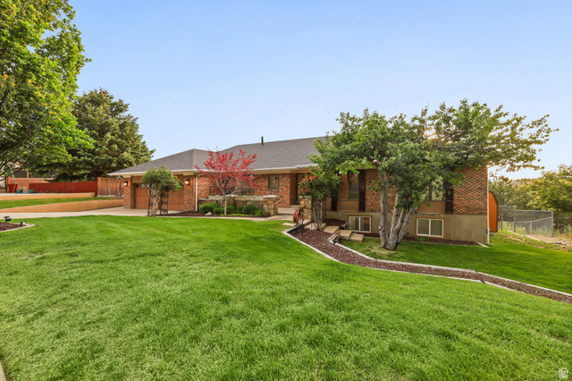 2342 Charros Road Sandy, UT 84092 - Photo 2 of 94 Expansive front lawn with mature trees and a brick facade residence