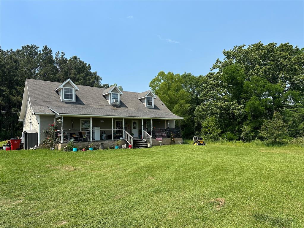 a view of a house with a yard and sitting area