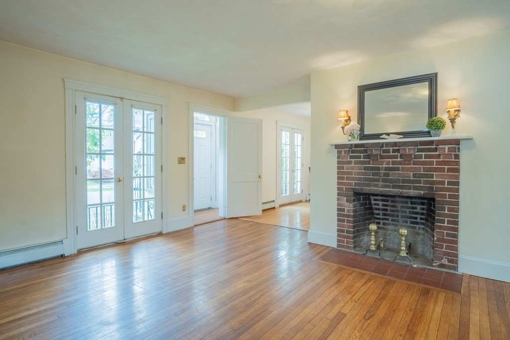 47 Pilgrim Road Marblehead, MA 01945 - Photo 12 of 42 an empty room with wooden floor fireplace and windows
