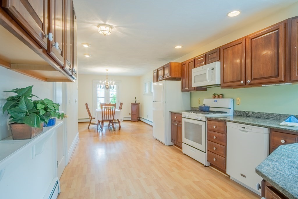47 Pilgrim Road Marblehead, MA 01945 - Photo 8 of 42 a kitchen with stainless steel appliances granite countertop a refrigerator a sink dishwasher a stove and white cabinets with wooden floor