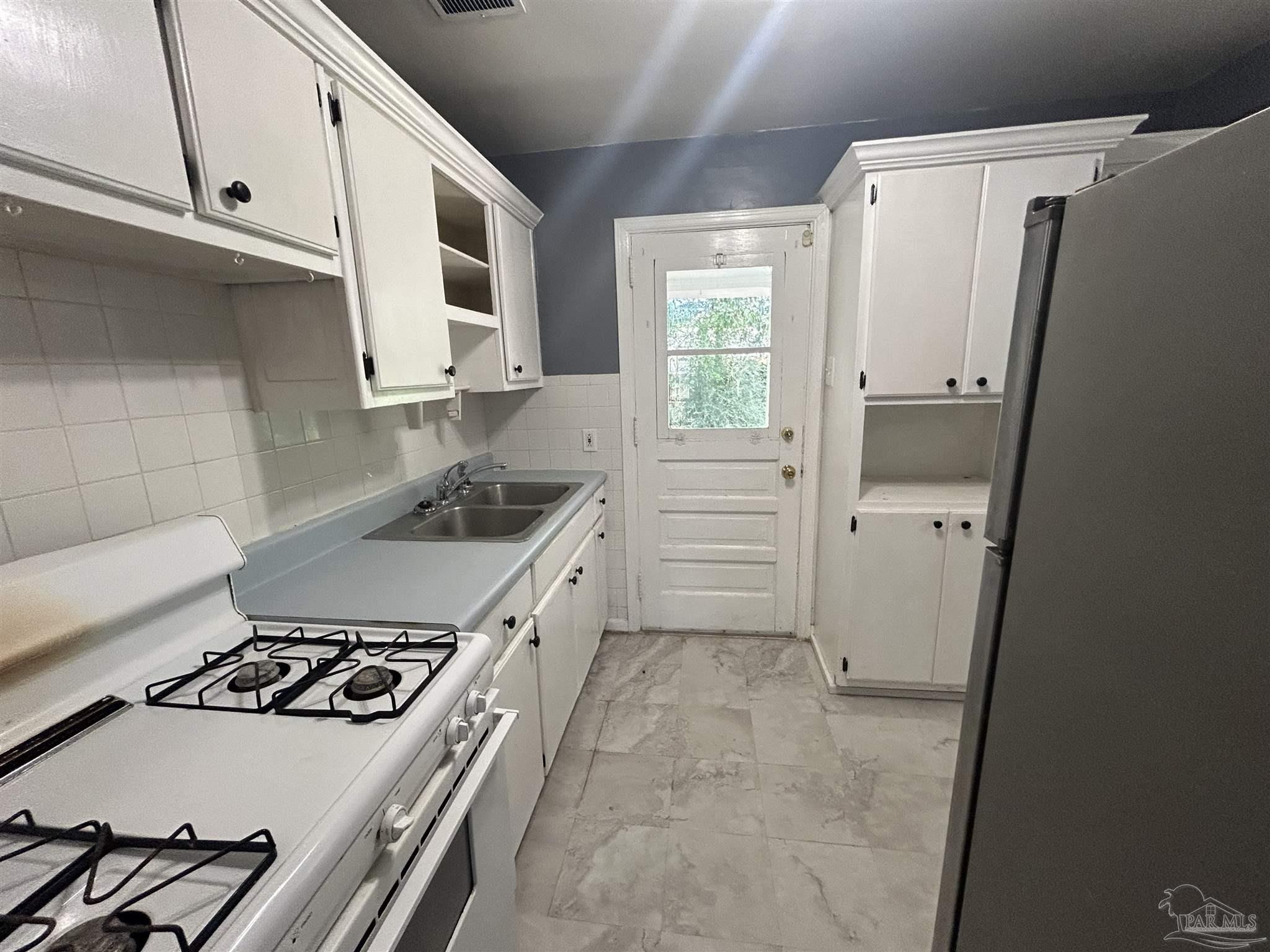 210 Milton Road Pensacola, FL 32507 - Photo 7 of 17 a kitchen with a white stove top oven and sink