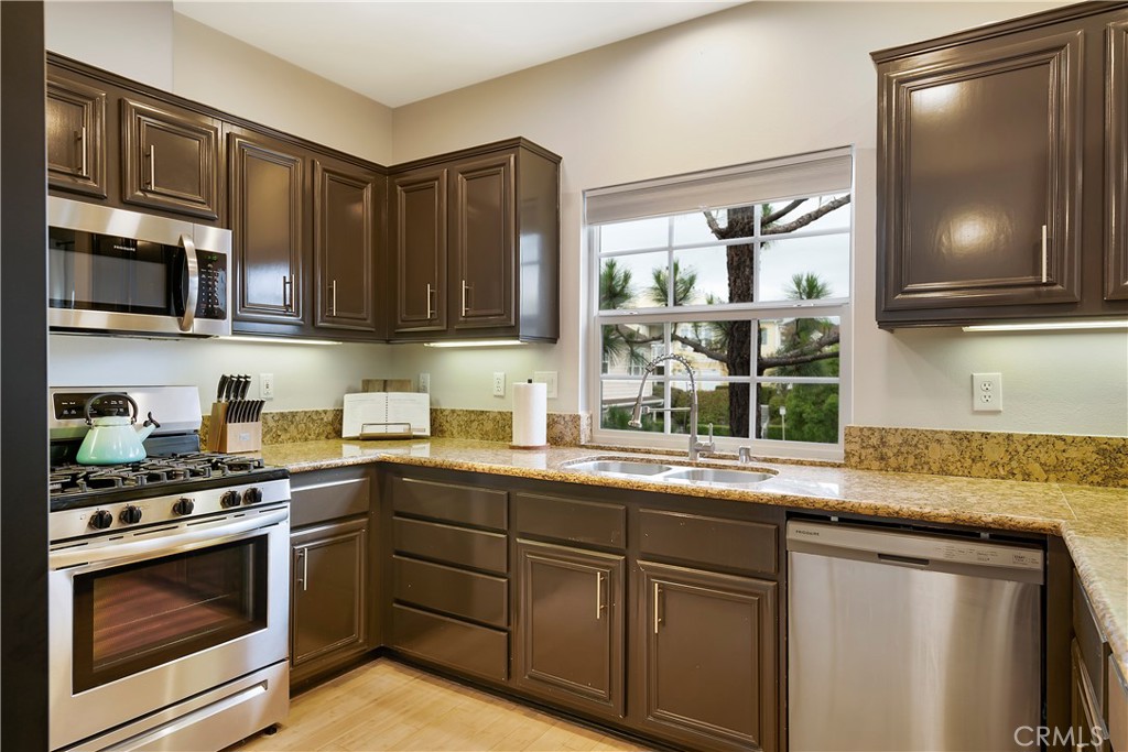 60 Strawflower Street Ladera Ranch, CA 92694 - Photo 10 of 34 a kitchen with stainless steel appliances granite countertop a sink stove and cabinets