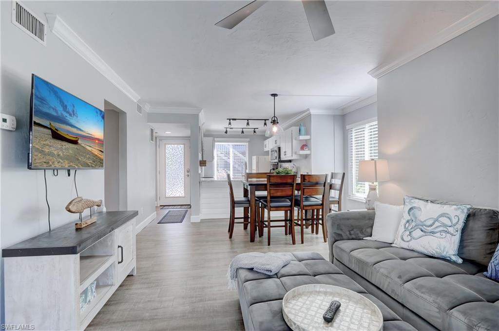 a living room with furniture a dining table and a chandelier