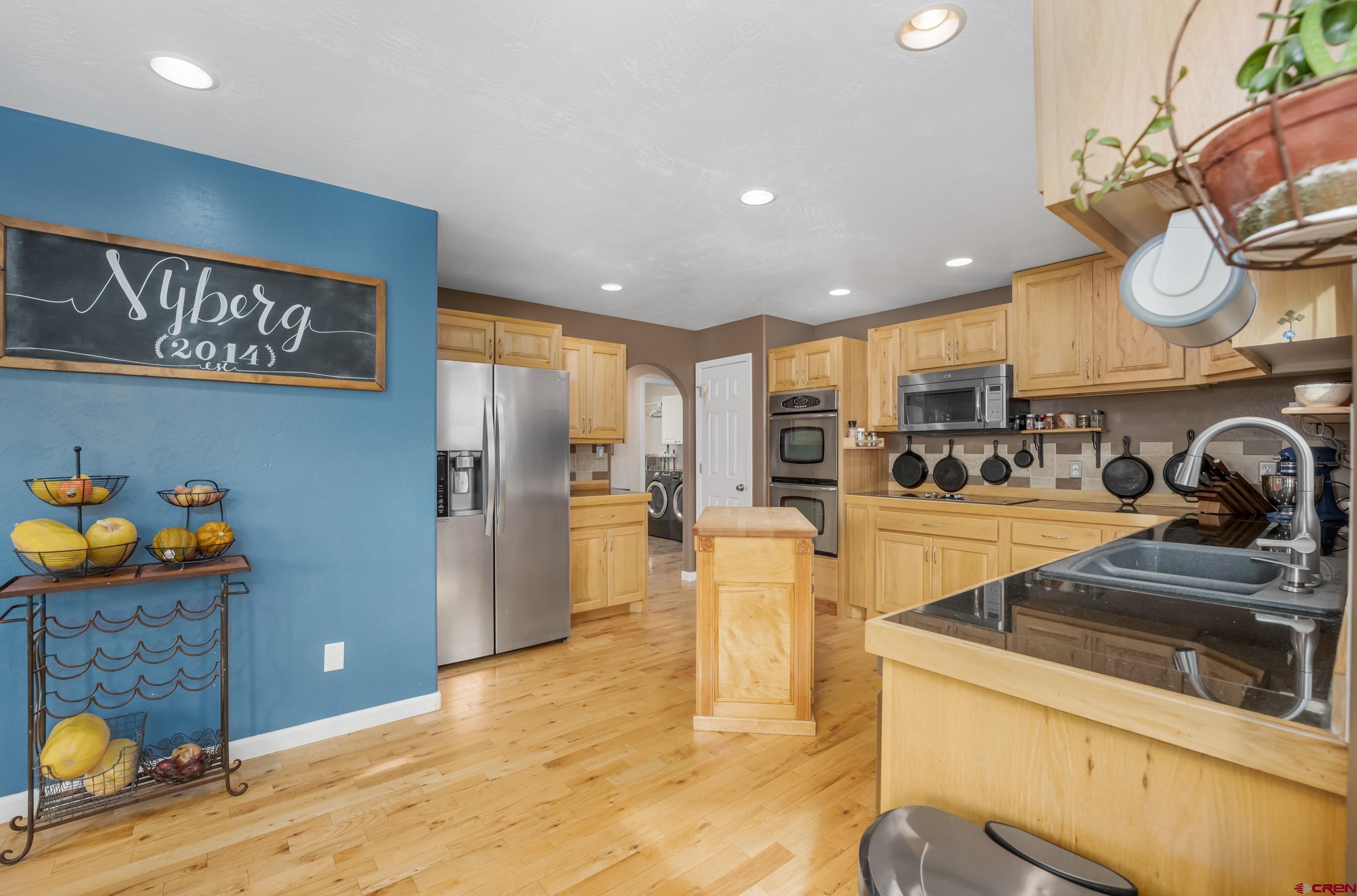 a kitchen with stainless steel appliances granite countertop a refrigerator and a sink