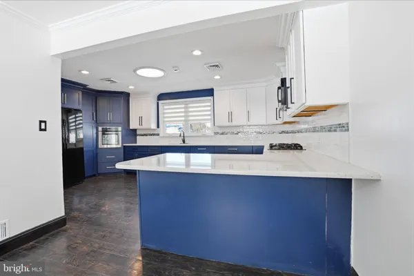 a large kitchen with stainless steel appliances a sink dishwasher stove refrigerator and cabinets