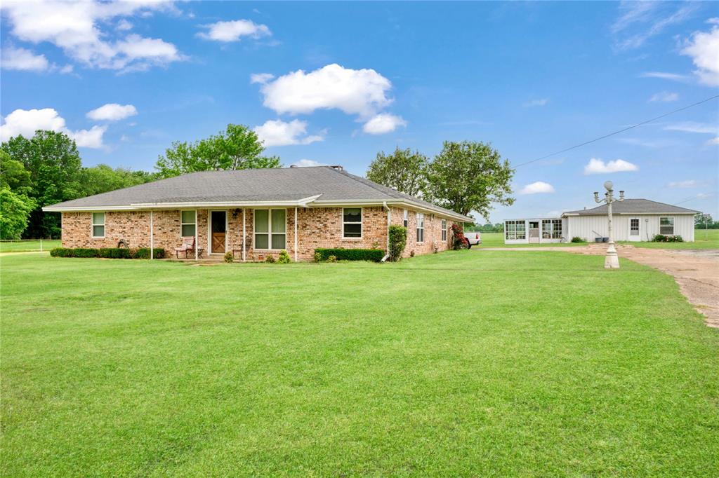 1355 County Road 33100 Sumner, TX 75486 - Photo 18 of 34 Ranch-style house with a front lawn, brick siding, dirt driveway, and roof with shingles