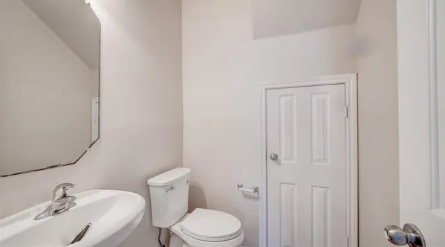 a white toilet sitting next to a bathroom sink