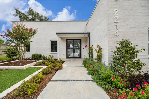 front view of a house with a yard and potted plants