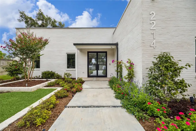 front view of a house with a yard and potted plants