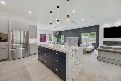 a kitchen with stainless steel appliances granite countertop a refrigerator a oven a sink and a refrigerator