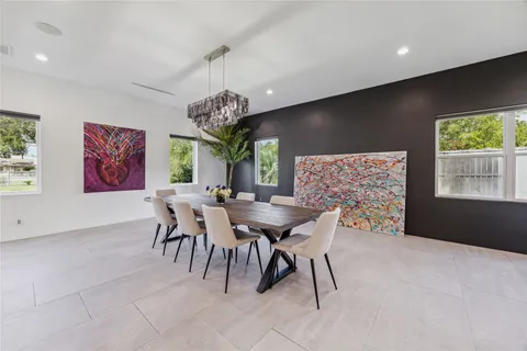 a view of a dining room with furniture a chandelier and window