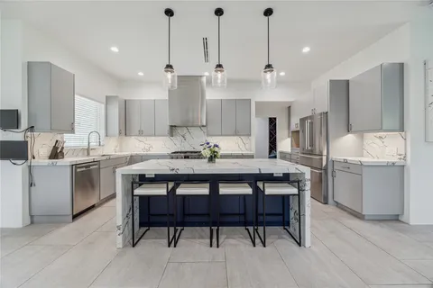 a kitchen with a dining table chairs sink and cabinets